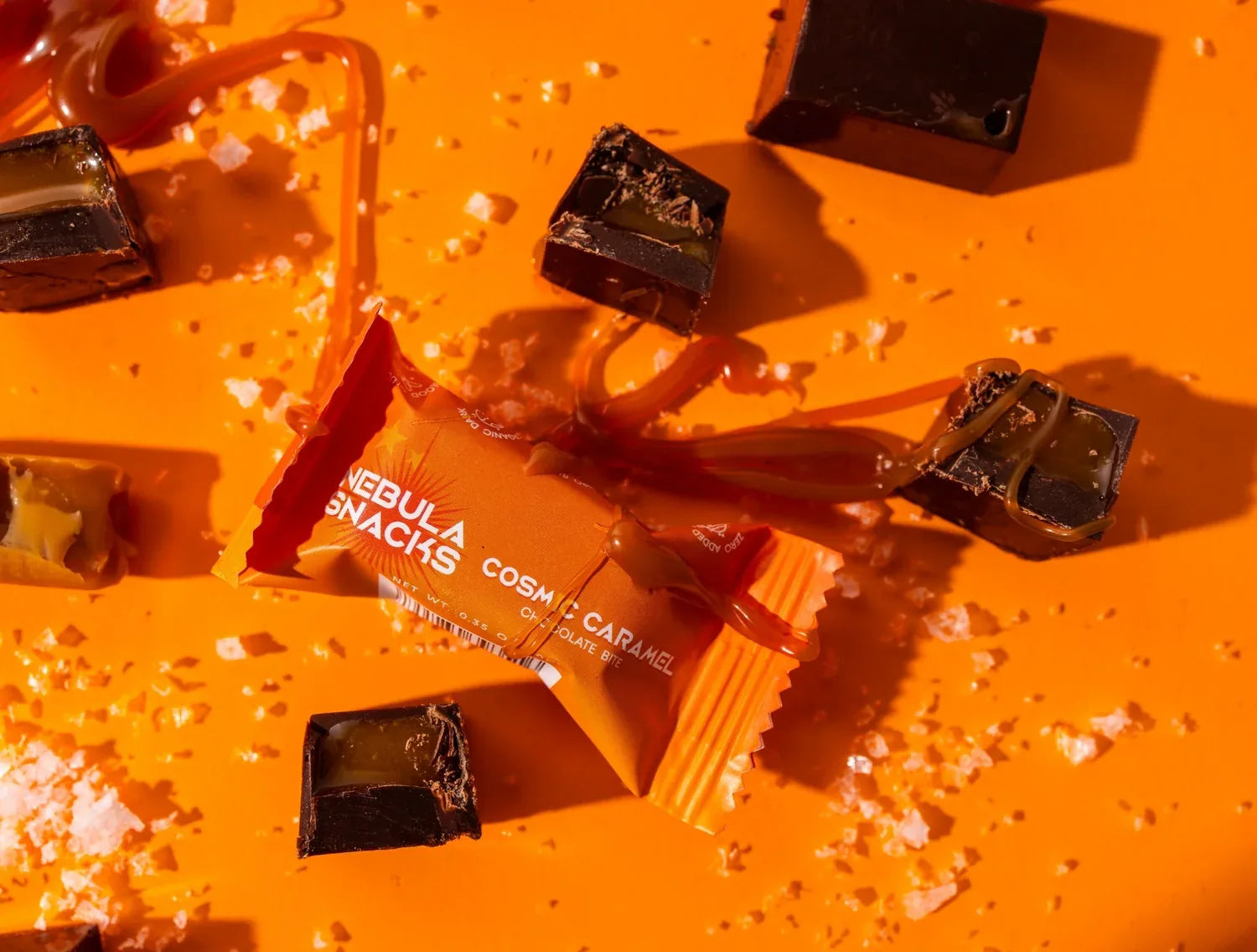 Cosmic Caramel chocolate bites cut open to show the caramel center, with caramel drizzle and flaky sea salt