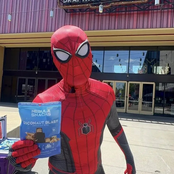 Spider-Man holding a pouch of Coconaut Blast outside Alamo Drafthouse
