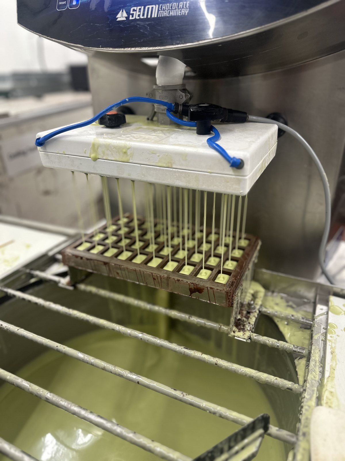 A depositor filling chocolate shells with mint filling for the first Nebula bites